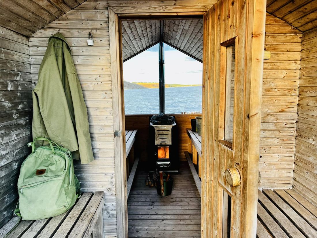 Vy ut genom bastudörren mot havet, med kaminen tänd.